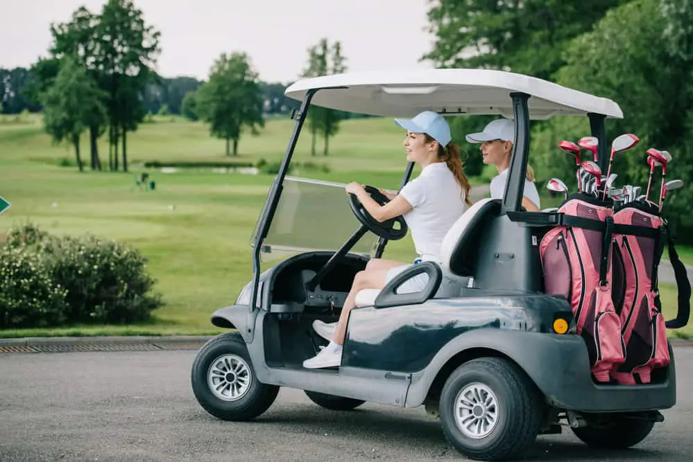 Two Females driving a Golf Cart